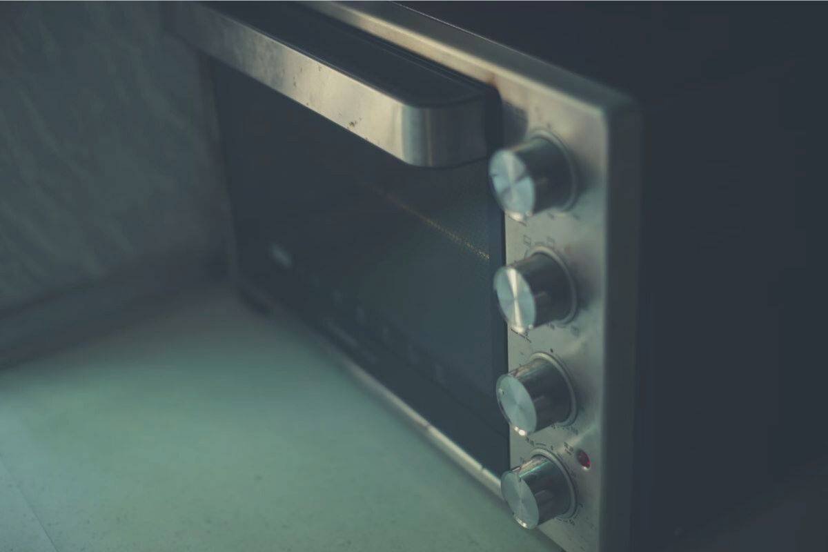 An old microwave oven sitting on a gray countertop