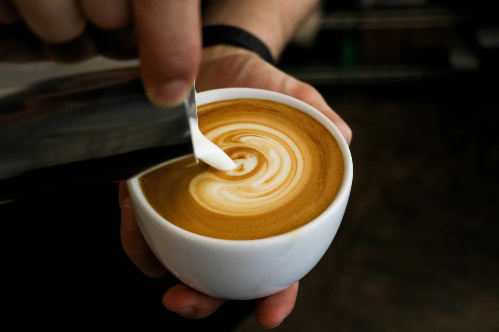 a close up of a cappuccino being poured
