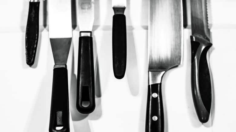 Kitchen knives hanging from a magnetic knife holder