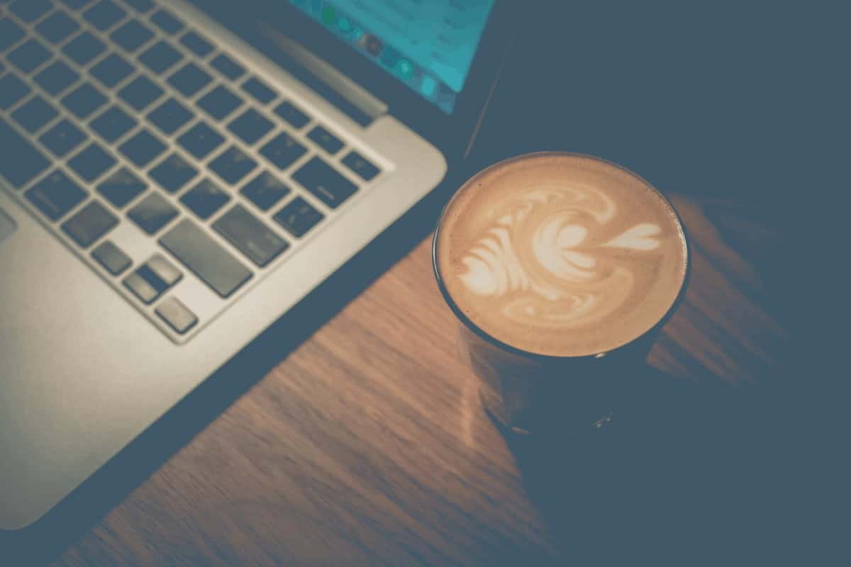Overhead shot of a latte next to a laptop