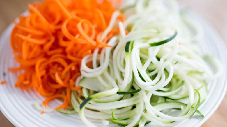 a close up shot of spiralized carrots and cucumber
