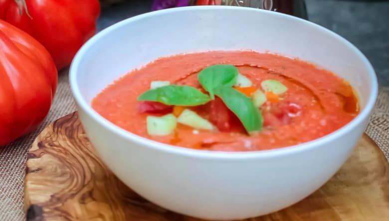 A bowl of tomato soup with garnish included