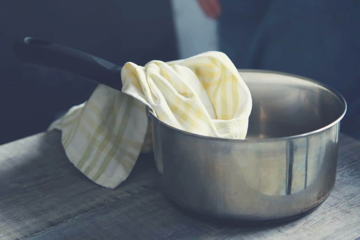 a saucepan with a cleaning cloth resting inside it
