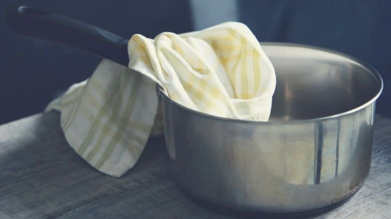 a saucepan with a cleaning cloth inside it