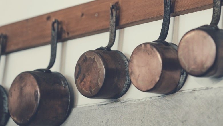 various pots and pans hanging from a rack