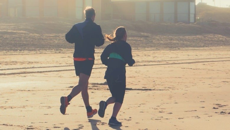 Two people jogging on a beach