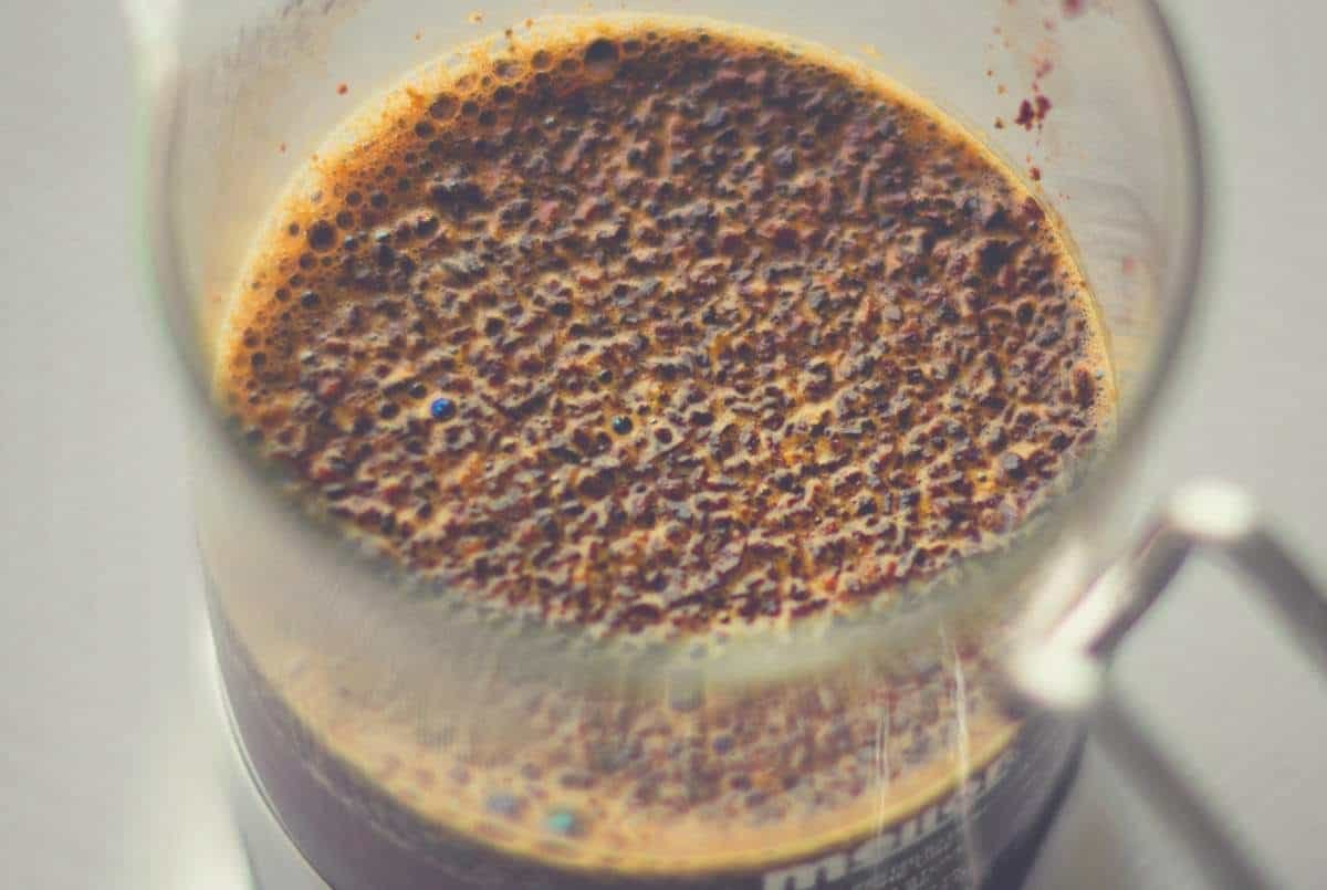 An overhead shot of coffee grounds settling in a French Press