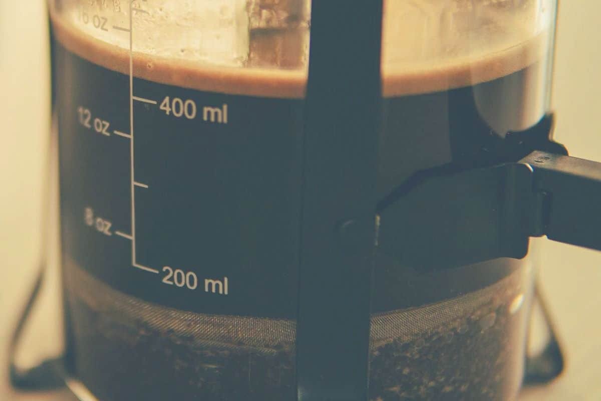 An extreme close up of a coffee plunger in a French Press