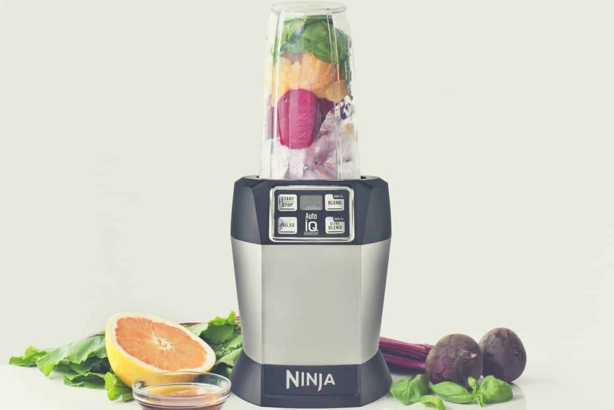 A Ninja Auto IQ blender filled with fruits and vegetables