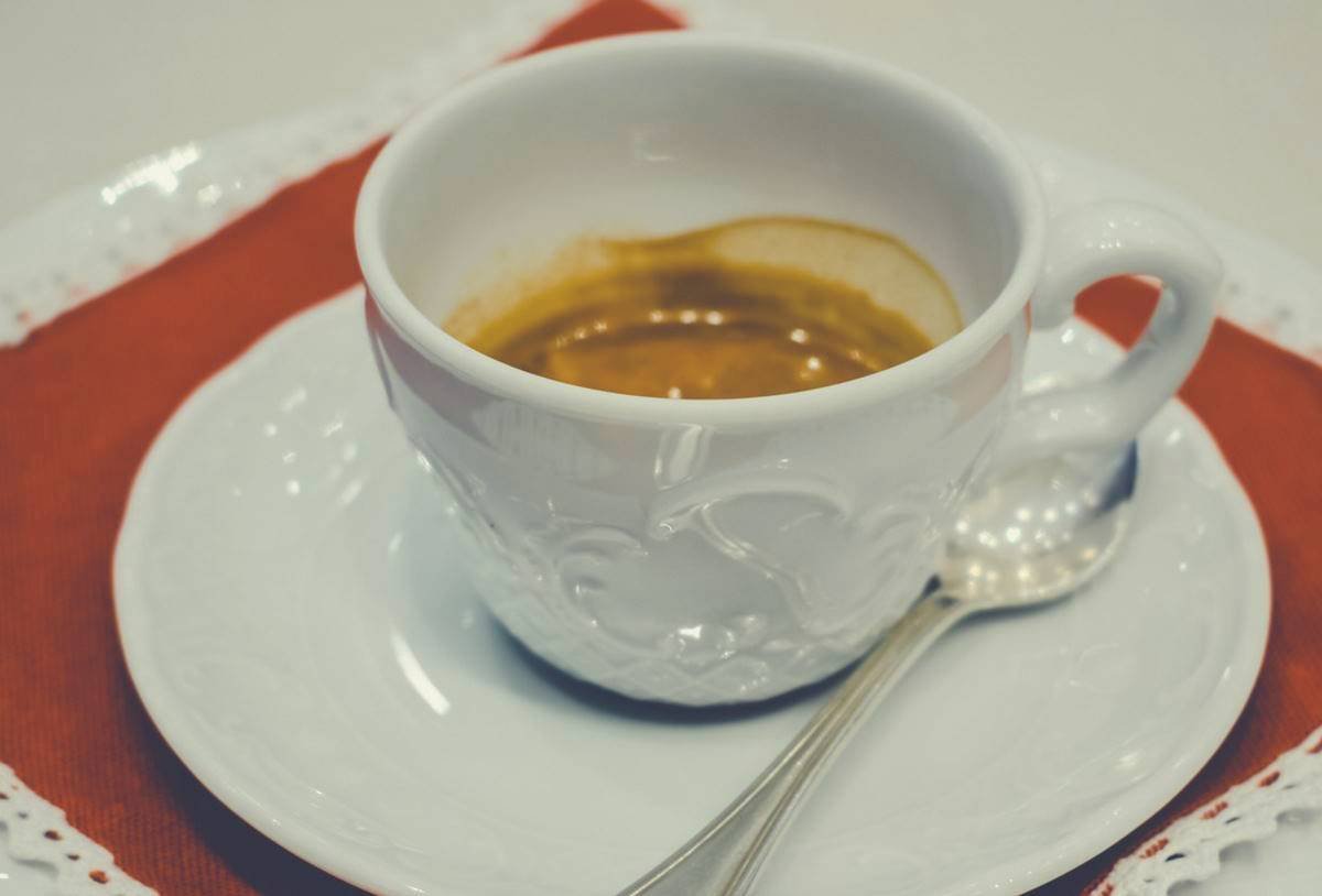 A cup of espresso on a saucer with a teaspoon