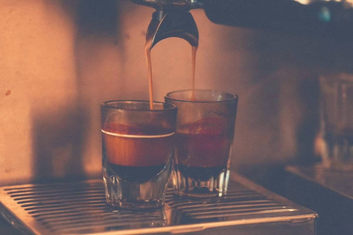 Two shots of espresso being brewed into glasses by an espresso machine