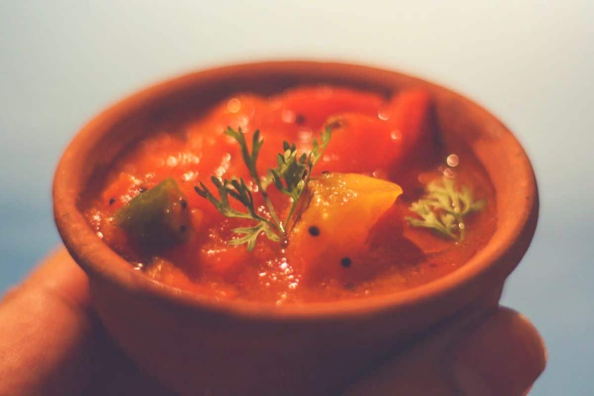 A tomato salsa dip in a brown ceramic pot