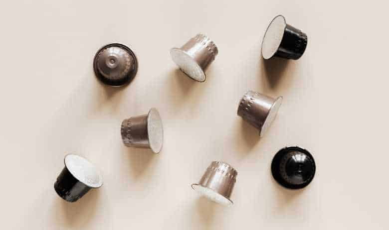 A selection of coffee pods scattered on a beige countertop