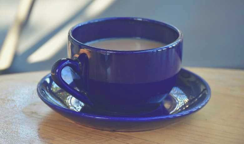 A blue coffee cup on a blue saucer