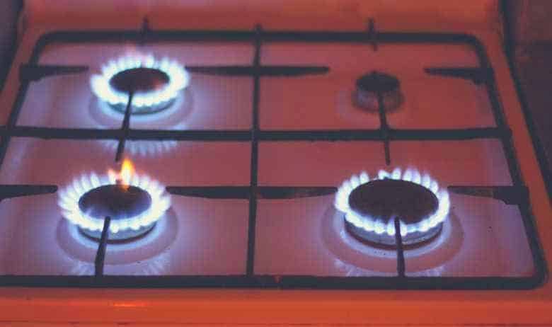 Three of four gas hobs lit on a gas stovetop
