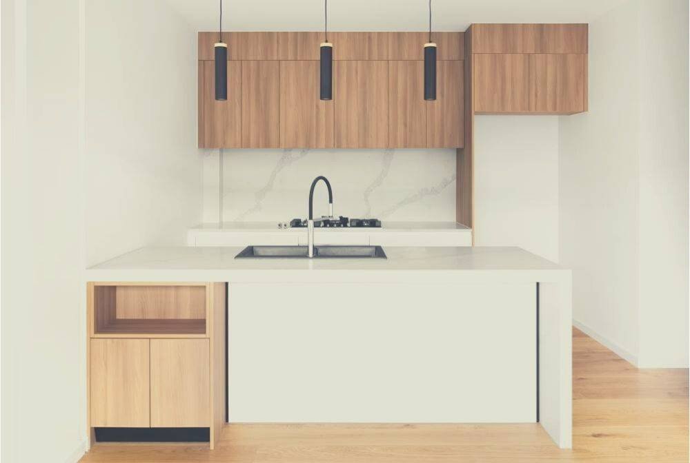 A Minimalist kitchen space with wooden cabinets and white workspace
