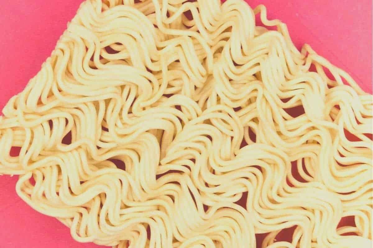 A slab of ramen noodles sitting on a pink tablecloth