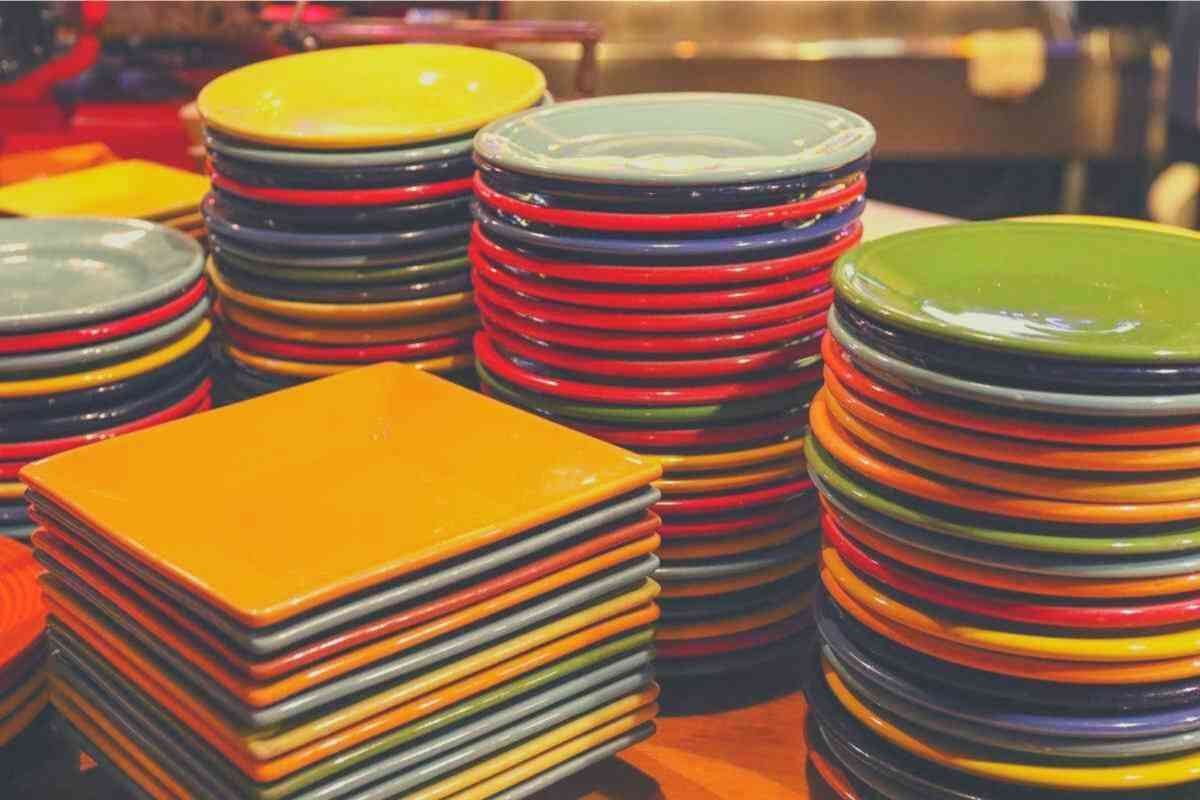 A large collection of colorful plates, arranged in stacks