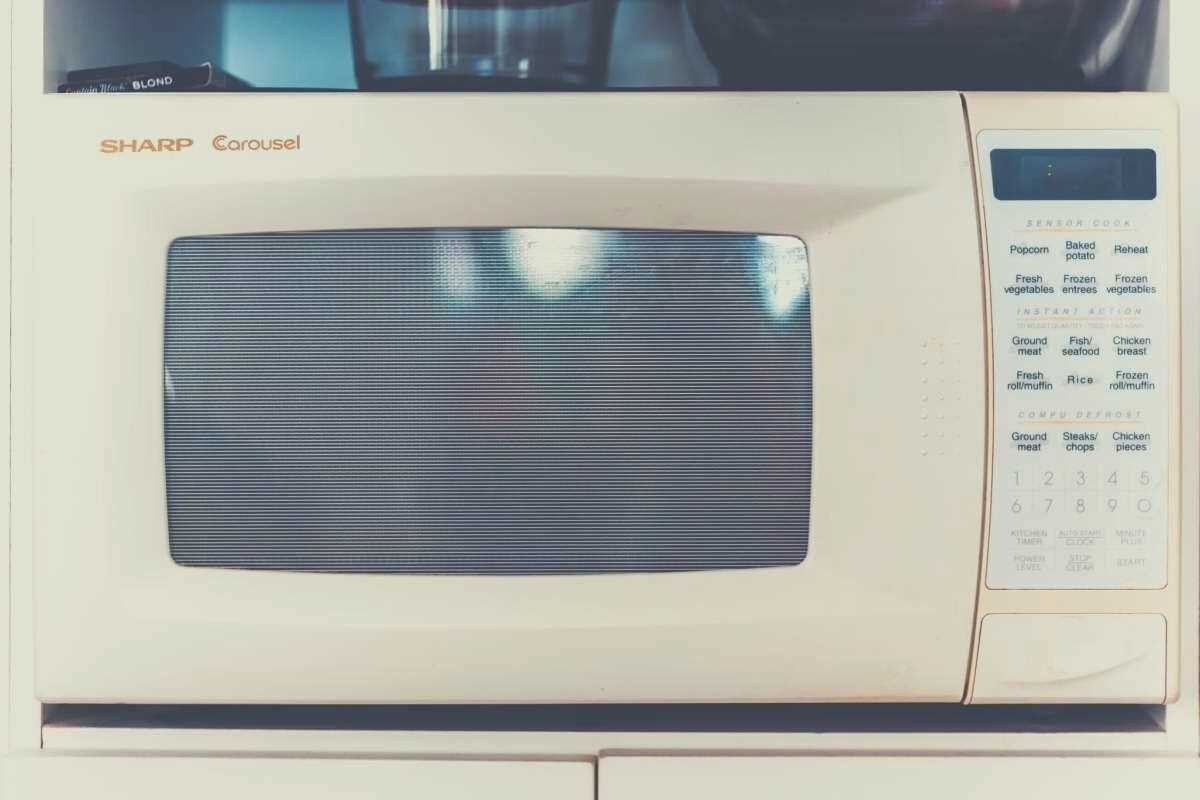 An old cream colored Sharp Carousel microwave