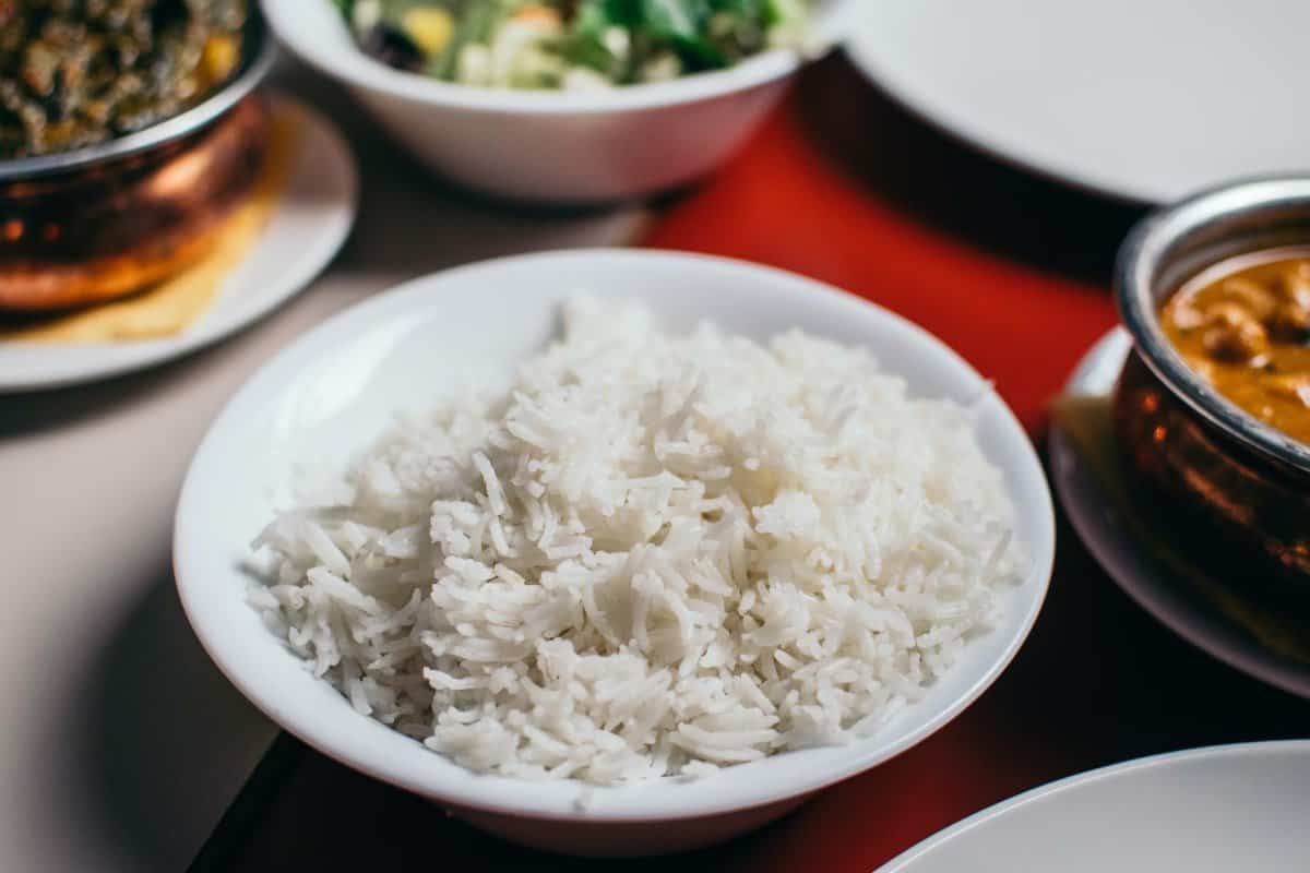 A bowl of fluffy rice alongside some other side dishes
